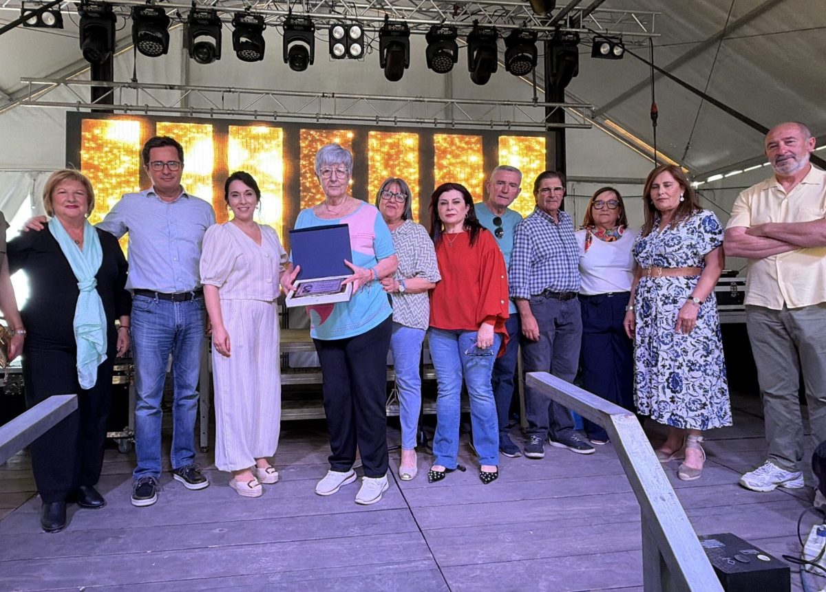 Trini Valdivia, presidenta del Club de la Tercera Edad de Ejido Norte, recibe una distinción durante las Fiestas en honor a la Santa Cruz