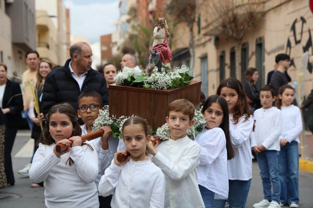 La procesión de la Borriquita recorre las calles de El Ejido portada por niñas y niños
